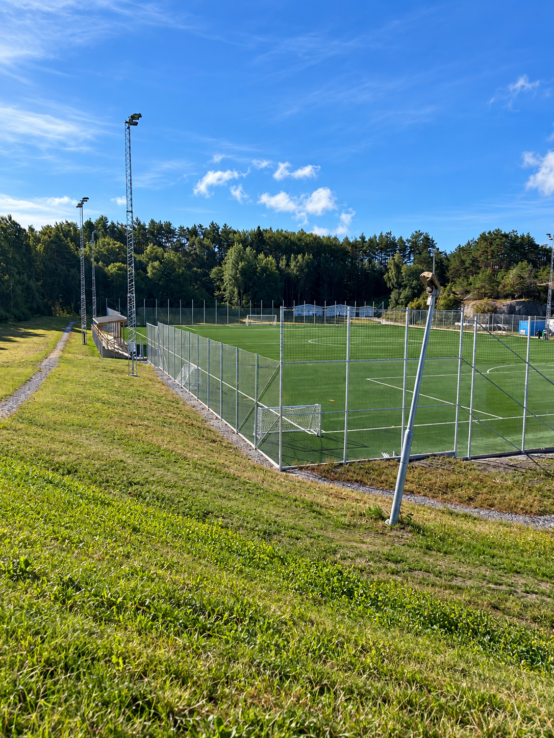 Fotbollsplan i Tanum – Bollfångststängsel i skogsmiljö.